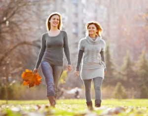Two female friends taking a walk in park.